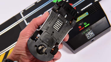 Auto Express product tester inspecting the underside of a slot car